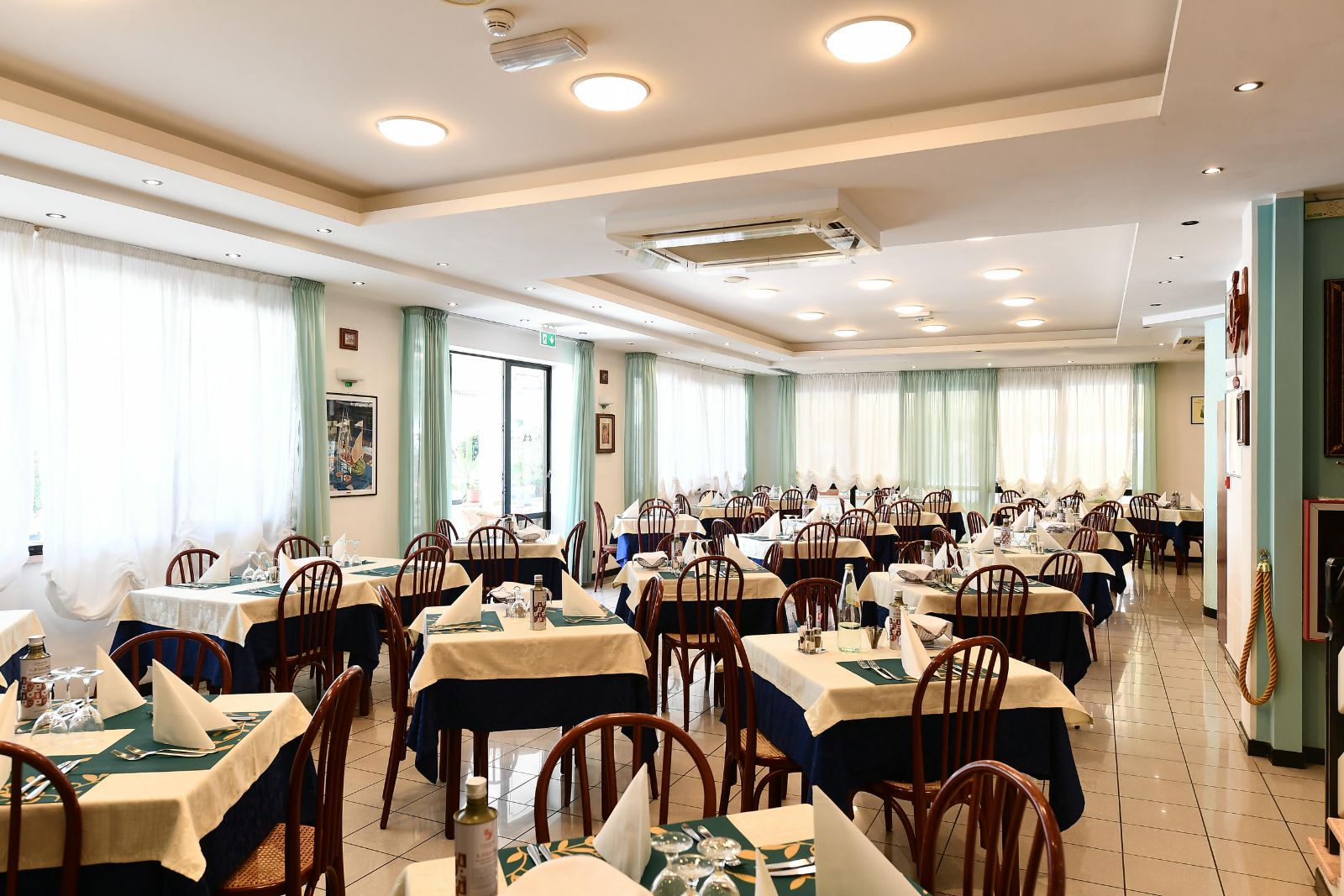 Sala da pranzo luminosa con tavoli apparecchiati